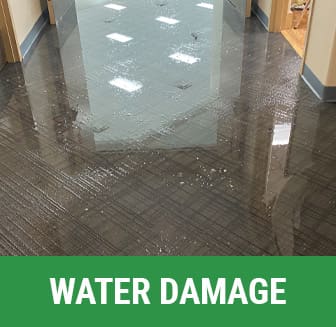 A flooded floor with the words water damage in front of it.